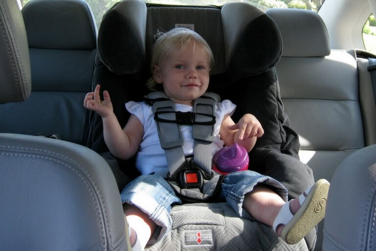 smiling child on car seat