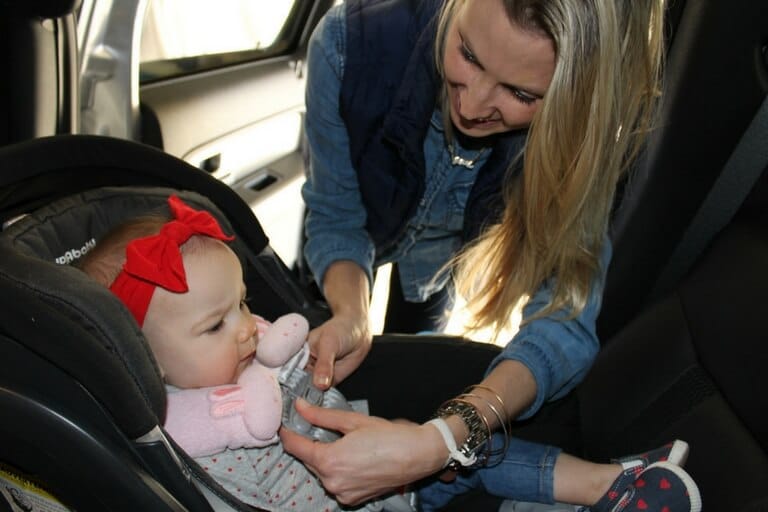 mom fixing baby on a car seat