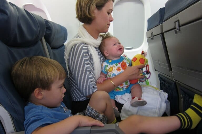 Baby, toddler, and a mother on a plane