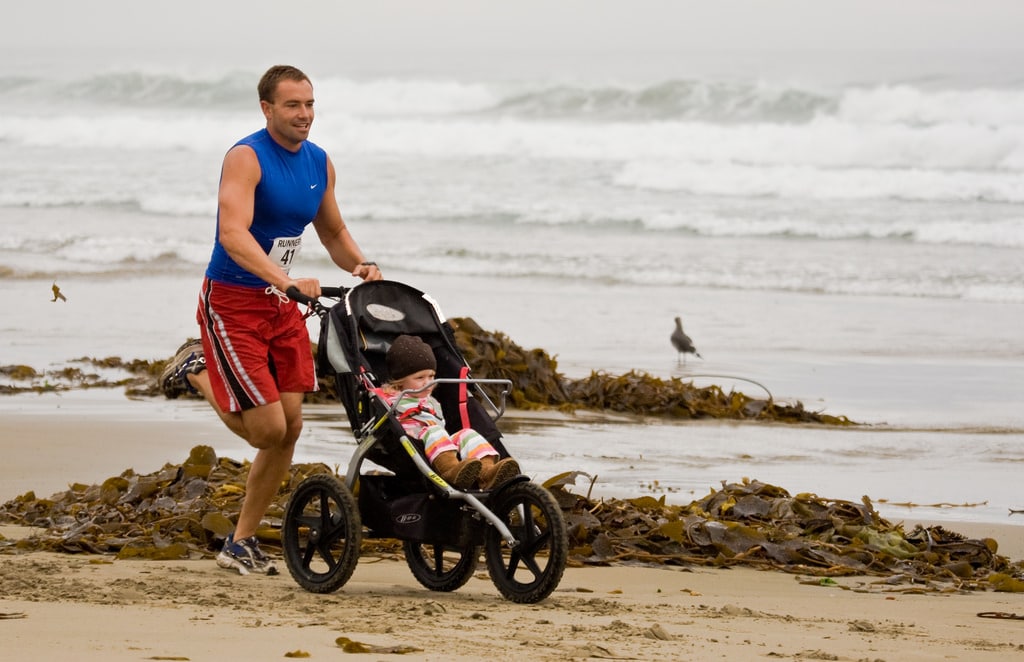 father running a marathon with baby in a stroller