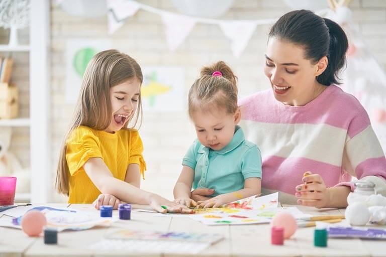 Mother and daughters painting together