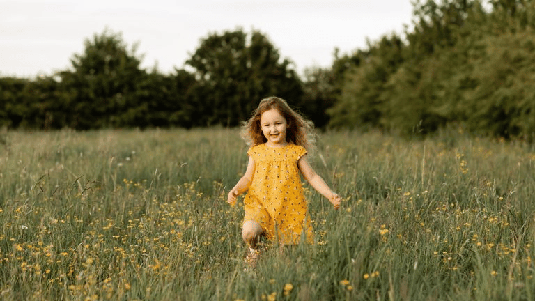 Female toddler walking on a field