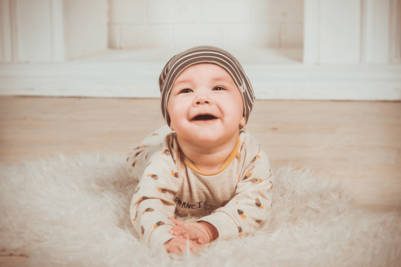 a cute smiling baby boy on the carpet