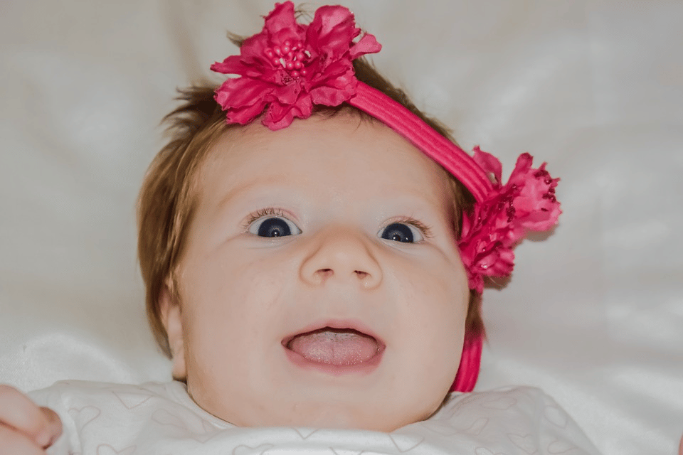 Funny baby with a red ribbon headband