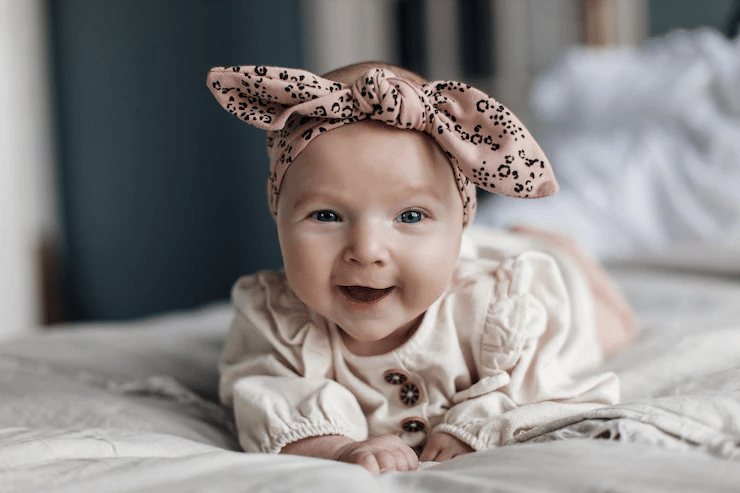 A baby smiling on the bed 