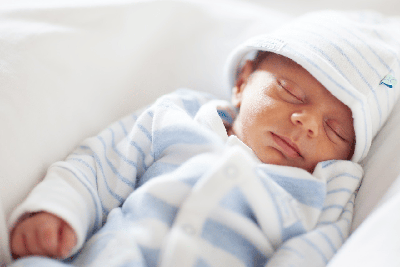 sleeping newborn baby in blue-striped clothing