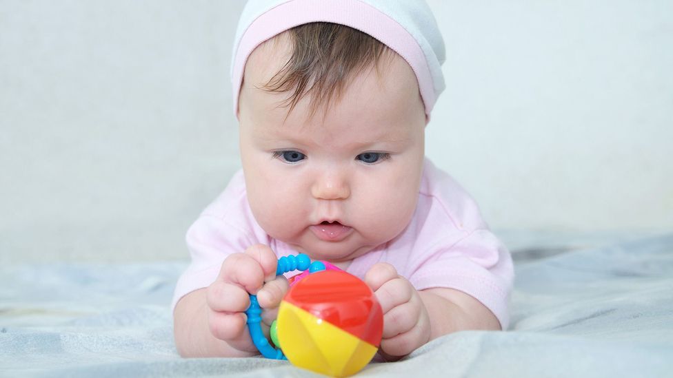 A baby holding a toy