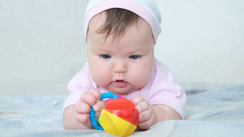A baby holding a toy A baby holding a toy