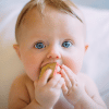 A baby with a building block in his mouth